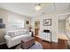 Inviting living room with hardwood floors, white sofa, and view into the en-suite bathroom at 190 Dale Pl, Oldsmar, FL 34677