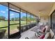 Enjoy golf course views from the screened-in porch with seating area and ceiling fan at 190 Dale Pl, Oldsmar, FL 34677