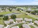 A sprawling aerial view of a community featuring homes, green spaces, ponds, and fairways at 2214 Highclere Cir # 6, Sun City Center, FL 33573