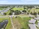 An aerial perspective showcases a well-maintained residential area alongside golf courses, green spaces, and ponds at 2214 Highclere Cir # 6, Sun City Center, FL 33573