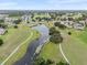 Expansive aerial view of a serene community featuring winding paths, lush greenery, and a tranquil lake at 2214 Highclere Cir # 6, Sun City Center, FL 33573