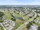 Expansive aerial view of a community with lush landscaping, golf course, and serene ponds under a bright blue sky at 2214 Highclere Cir # 6, Sun City Center, FL 33573