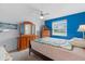 Bedroom featuring carpet flooring, a bright blue accent wall, and a large window at 2214 Highclere Cir # 6, Sun City Center, FL 33573