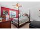 Bedroom featuring a four-poster bed, carpet flooring, and a bright red accent wall at 2214 Highclere Cir # 6, Sun City Center, FL 33573