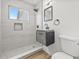 Modern bathroom features a floating vanity and tiled shower with a small window for natural light at 2233 Rightaway Ln, Plant City, FL 33565