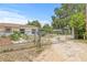 Exterior home shot with fenced yard featuring a charming metal gate and desert landscaping at 2233 Rightaway Ln, Plant City, FL 33565