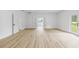 Sun-filled living room with light wood flooring and white walls and a glass door to backyard at 2233 Rightaway Ln, Plant City, FL 33565