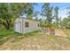A storage shed sits on a shady lot with outdoor seating and an adjacent grassy yard at 2233 Rightaway Ln, Plant City, FL 33565