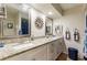 Well-lit bathroom with granite countertops, dual sinks, and ample storage in white cabinets at 2238 Lark W Cir # D, Palm Harbor, FL 34684
