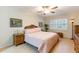 Comfortable bedroom featuring a ceiling fan and a window with white shutters for natural light at 2238 Lark W Cir # D, Palm Harbor, FL 34684