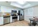 Bright kitchen featuring stainless steel appliances, granite countertops, and white cabinets at 2238 Lark W Cir # D, Palm Harbor, FL 34684