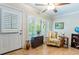 Bright sun room featuring hardwood floors, shutters, neutral walls, and modern furniture at 2238 Lark W Cir # D, Palm Harbor, FL 34684