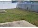 Backyard with green grass, a concrete patio and partial white privacy fence with chain link at 2603 Mary Sue Sw St, Largo, FL 33774