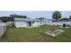 Spacious backyard featuring a concrete patio, a grassy area, and a white fence at 2603 Mary Sue Sw St, Largo, FL 33774