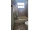 Bathroom showing the tub with marble-like tile, curtain, and toilet at 2603 Mary Sue Sw St, Largo, FL 33774
