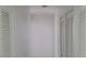 Hallway features neutral paint, louvered closet doors, and access to other rooms in the home at 2603 Mary Sue Sw St, Largo, FL 33774