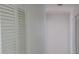 Hallway features neutral paint, louvered closet doors, and access to other rooms in the home at 2603 Mary Sue Sw St, Largo, FL 33774
