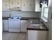 Functional kitchen featuring white appliances, a double sink, and white cabinetry at 2603 Mary Sue Sw St, Largo, FL 33774