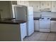 Functional kitchen featuring white appliances, ample cabinet space, and tile flooring at 2603 Mary Sue Sw St, Largo, FL 33774