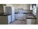 Functional kitchen featuring white appliances, ample cabinet space, and tile flooring at 2603 Mary Sue Sw St, Largo, FL 33774