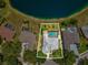 Aerial view of the property showcasing a private pool, fenced yard, and pond frontage at 2730 River Woods Dr, Parrish, FL 34219
