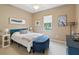 Inviting bedroom featuring blue accents, including bedframe and ottoman, complemented by neutral walls and plush carpeting at 2730 River Woods Dr, Parrish, FL 34219