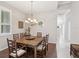 Inviting dining room with rustic wooden table and chairs, complemented by a chandelier and natural light at 2730 River Woods Dr, Parrish, FL 34219