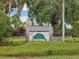 Landscaped community sign for River Woods featuring lush greenery and stone accents at 2730 River Woods Dr, Parrish, FL 34219