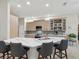 Open kitchen with stainless steel appliances, quartz countertops, large island, and bar stool seating at 2730 River Woods Dr, Parrish, FL 34219