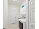 Bright laundry room with white cabinets, tile floor, and white doors and trim at 2730 River Woods Dr, Parrish, FL 34219