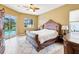 This primary bedroom features a large wooden sleigh bed and sliding glass doors to the pool area at 2730 River Woods Dr, Parrish, FL 34219