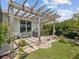 Outdoor patio area with pergola, grill, brick pavers, and lush greenery at 2730 River Woods Dr, Parrish, FL 34219