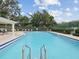 Inviting community pool area with lounge chairs, shaded seating, and well-maintained surroundings at 2730 River Woods Dr, Parrish, FL 34219