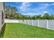 Manicured backyard featuring a well-kept lawn and a secure white vinyl fence for privacy at 30445 Tremont Dr, Wesley Chapel, FL 33543