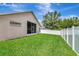 Spacious backyard featuring lush green lawn, privacy fence, and screened patio area at 30445 Tremont Dr, Wesley Chapel, FL 33543