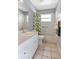 Bright bathroom featuring a shower and tub combination with gray walls and a vanity mirror at 30445 Tremont Dr, Wesley Chapel, FL 33543