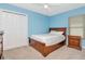 Bedroom with light-blue walls, a wooden bed frame, and double-door closet at 30445 Tremont Dr, Wesley Chapel, FL 33543