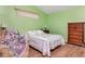 Comfortable bedroom featuring a bed, wooden floors, a recliner, and a wooden dresser at 30445 Tremont Dr, Wesley Chapel, FL 33543