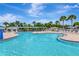 Expansive community pool area with clear blue water, lounge chairs, and covered seating at 30445 Tremont Dr, Wesley Chapel, FL 33543