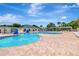 Community pool with blue water, lounge chairs, slides and covered eating area with palm trees at 30445 Tremont Dr, Wesley Chapel, FL 33543