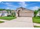 Charming home featuring a two-car garage and beautifully landscaped front yard with palm trees, perfect for curb appeal at 30445 Tremont Dr, Wesley Chapel, FL 33543