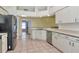 Kitchen featuring stainless steel appliances, white cabinets, tile flooring, and an open layout at 30445 Tremont Dr, Wesley Chapel, FL 33543