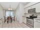 Bright kitchen with stainless steel appliances, white cabinets, and adjacent dining area at 30445 Tremont Dr, Wesley Chapel, FL 33543