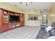 Spacious living room features tile flooring, large media center, and an open layout to the kitchen at 30445 Tremont Dr, Wesley Chapel, FL 33543
