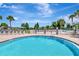 Resort-style pool area with clear blue water, lounge chairs, umbrellas, and nearby playground at 30445 Tremont Dr, Wesley Chapel, FL 33543