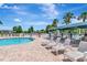 Community pool and splash pad area complete with lounge chairs, tables, umbrellas, and a playground nearby at 30445 Tremont Dr, Wesley Chapel, FL 33543