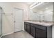 Bathroom features a double sink vanity with dark wood cabinets and a glass-enclosed shower at 30989 Summer Sun Loop, Wesley Chapel, FL 33545