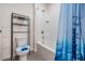 Bright bathroom with a shower over tub with blue curtain, and a white toilet at 30989 Summer Sun Loop, Wesley Chapel, FL 33545