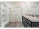 Bathroom features a double sink vanity with dark wood cabinets and a glass-enclosed shower at 30989 Summer Sun Loop, Wesley Chapel, FL 33545
