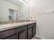 Bright bathroom featuring double sinks with dark cabinets and a large mirror at 30989 Summer Sun Loop, Wesley Chapel, FL 33545